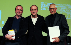 Produzent Josef Aichholzer (r) und Redakteur Wolfgang Feindt (l) nehmen am 14.03.2014 in Wiesbaden (Hessen) für den ZDF-Film «Spuren des Bösen - Zauberberg» den Deutschen Fernsehkrimi-Preis von Schirmherr und Schauspieler Ulrich Tukur entgegen. Die Auszeichnung wurde bei der Abschlussgala des 10. FernsehKrimi-Festivals vergeben und ist mit 1000 Liter Wein dotiert. Bei dem sechstägigen Festival wurden herausragende TV-Krimiproduktionen im Kino gezeigt. Foto: Daniel Reinhardt/dpa +++(c) dpa - Bildfunk+++