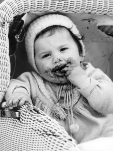 Ein kleines Kind in einem Kinderwagen futtert am 21.05.1964 Schokolade. Mund und Hände sind bereits völlig von der schmelzenden Leckerei verschmiert. Die Babyboomer-Jahrgänge der 60er Jahre haben sich nach Einschätzung des Historikers Nolte nicht zu einer richtigen Generation vergleichbar mit den 68ern entwickelt. Die 64er waren der geburtenstärkste Jahrgang in der deutschen Geschichte. (Foto: dpa)