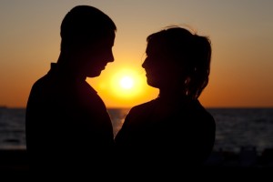ARCHIV - Ein Paar steht bei Sonnenuntergang am Ostseestrand von Warnemünde, aufgenommen am 23.06.2009. Immer mehr Menschen leben trotz fester Beziehung in getrennten Wohnungen. Foto: Arno Burgi/dpa